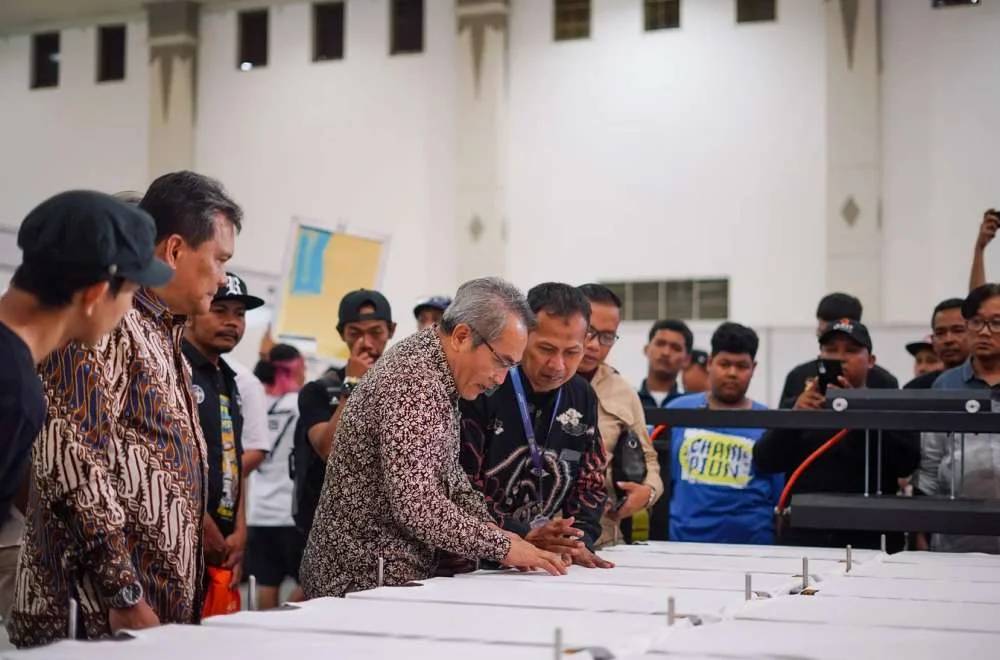Pengunjung Melihat Demonstrasi Mesin Printing Dan Sablon Pada Acara Kenduri Sablon Jogja 2026 Di Area Pameran Industri Tekstil.